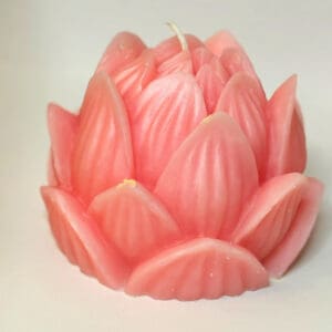 A pink candle is shaped like a flower.